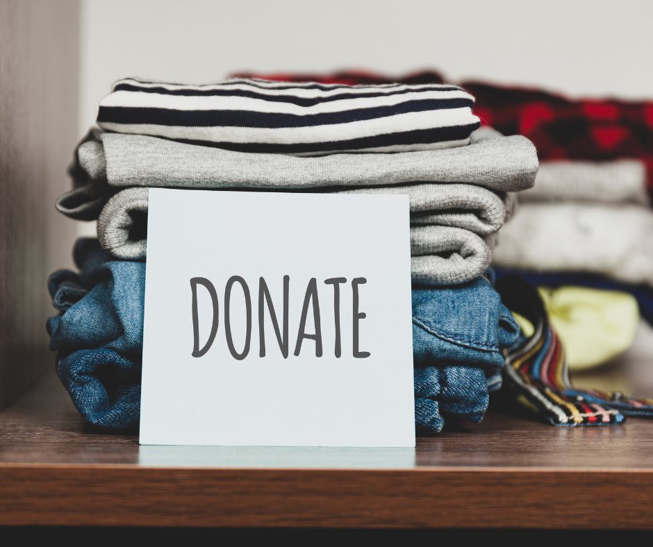 Stack of folded clothes with a donate sign, ready for a doorstep donation pickup